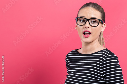 Young woman talking on a pink background