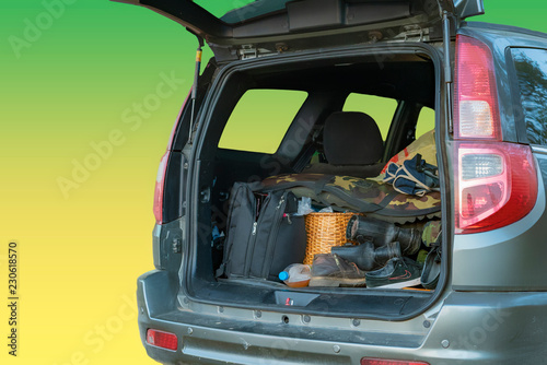 isolated opened car trunk with luggage on yellow background f