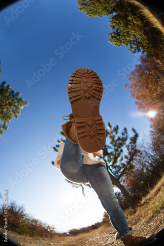 Fish eye low angle view on woman hiking and walking in nature