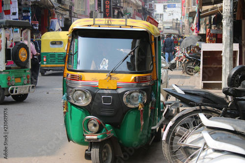 Indian car on the road is worth. Market in India. Three-wheeled car in India.