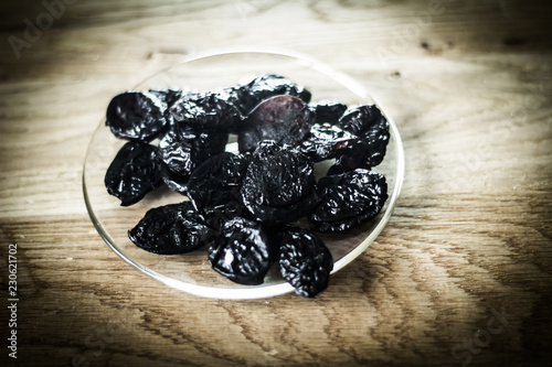 closeup.prunes in a bowl and muesli on a wooden table