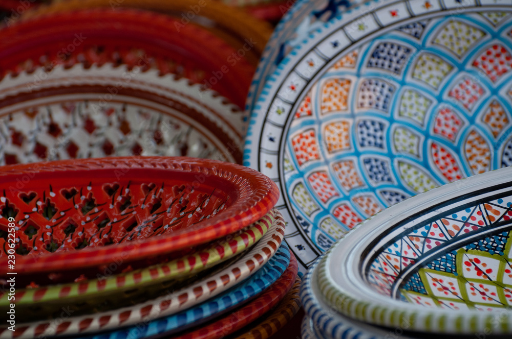Colorful ethnic round collectible ceramic plates for sale on the market. Set of decorated plates to hang on the wall or as a table centerpiece