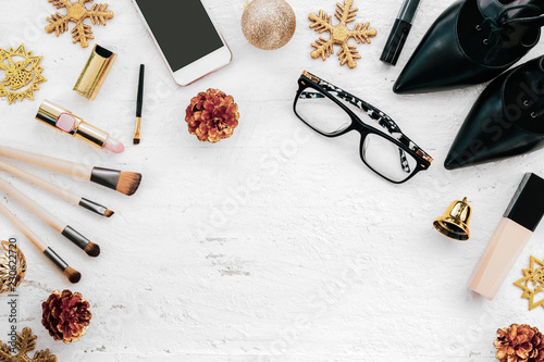 Merry Christmas and Happy new year fashion concept : Flat lay of woman accessories, cosmetics, smartphone and Christmas ornaments on rusty white wood background