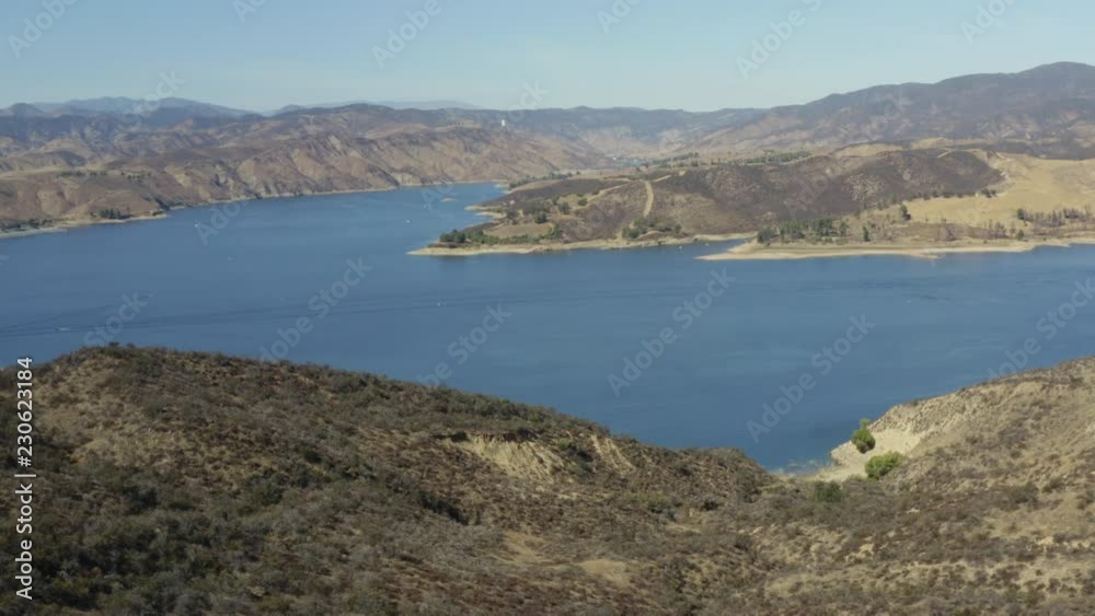 A blue lake in between hills with power boats and kayaks A blue lake in between hills with power boats and kayaks