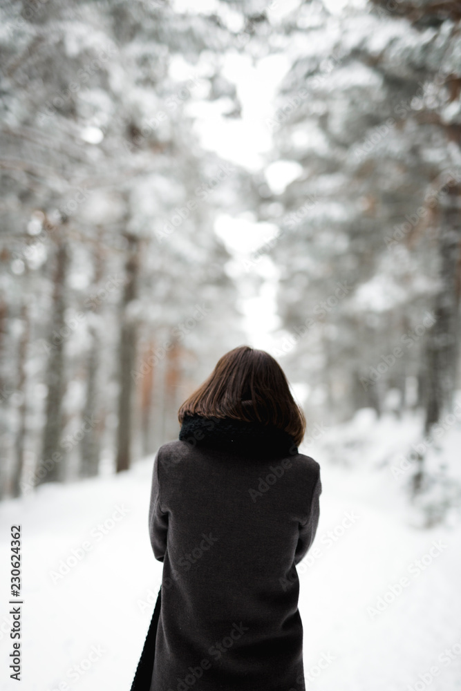 Young woman standing near trees in winter Young woman standing near trees in winter