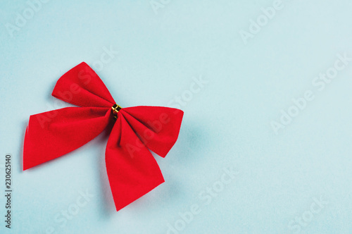 Single red tied bow on blue background with copy space for your text