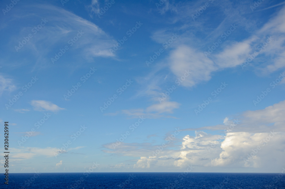 Sea horizon against the blue sky with clouds.