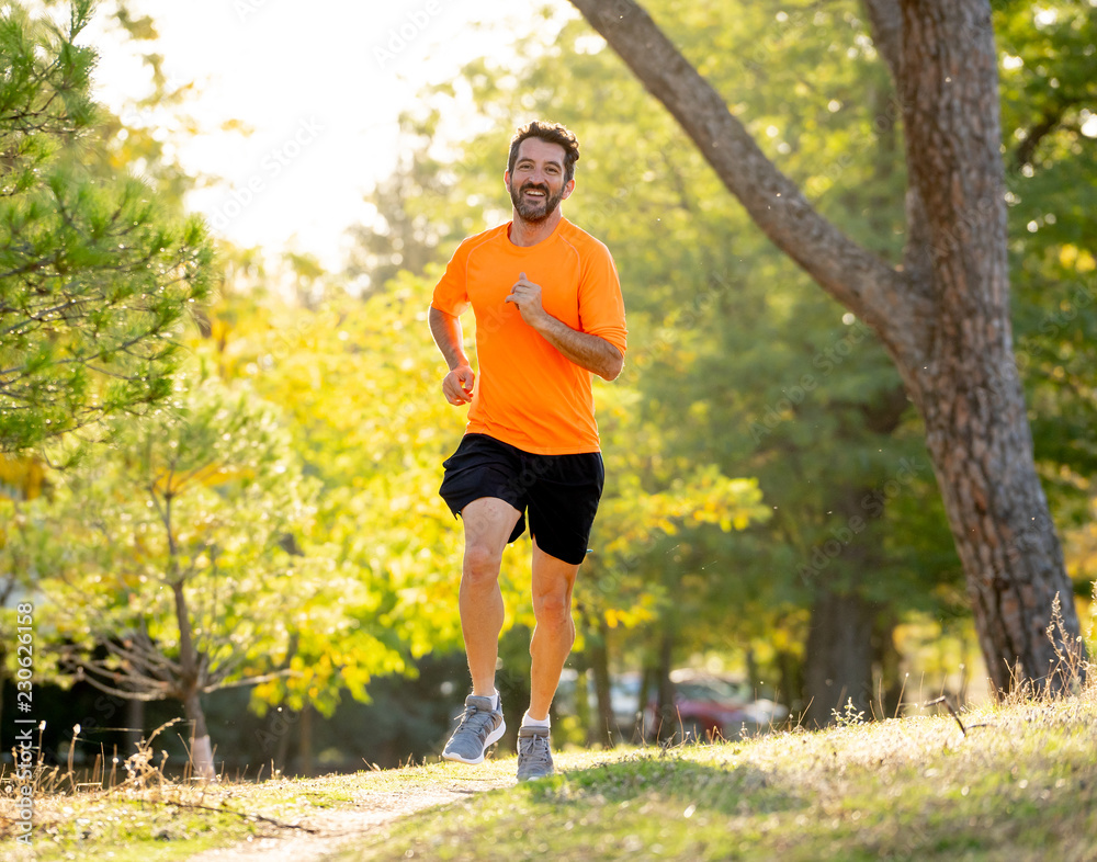 Athletic young man running in the nature at sunset in autumn in fitness Healthy lifestyle