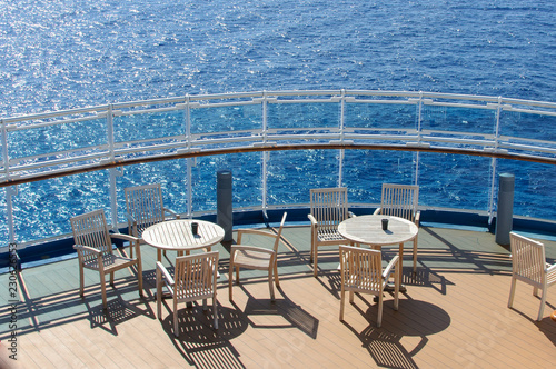 View from the deck of a cruise ship in the ocean. Seating area for passengers, chairs and sun loungers. Sunbathe. © DOF