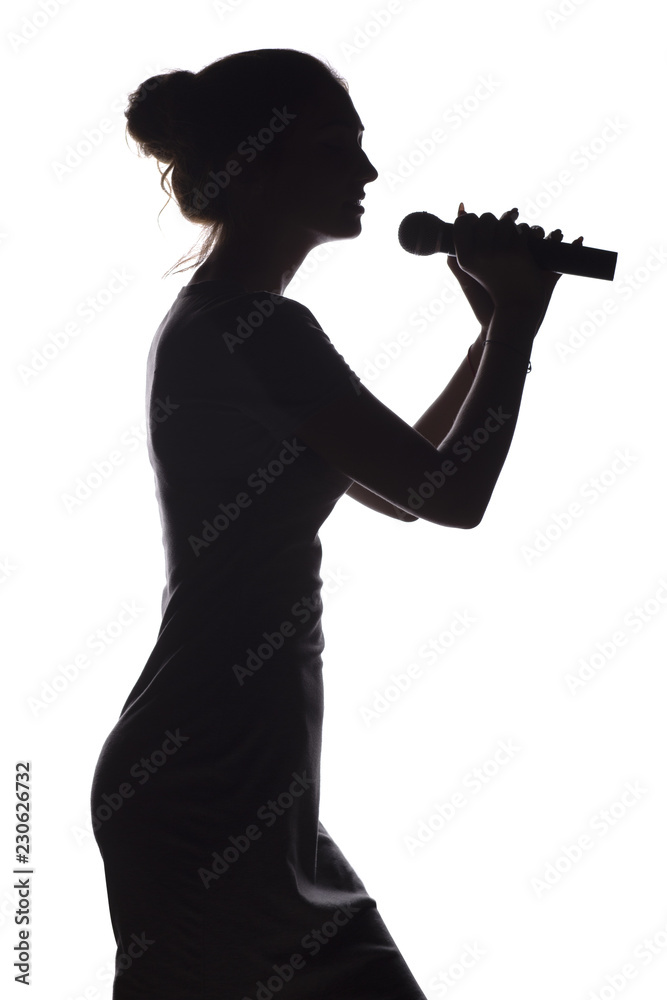 silhouette of girl singing into microphone, profile of young woman face performing lyric song on white isolated background