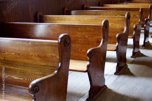 Carved Wooden pews in church in sunshine photo