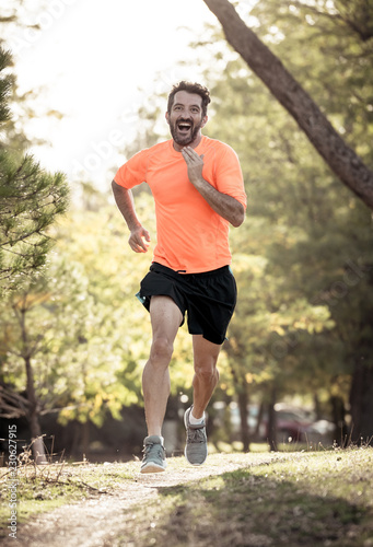 Athletic young man running in the nature at sunset in autumn in fitness Healthy lifestyle