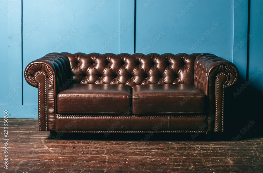 luxurious leather, brown sofa, blue wall. classic vintage furniture. Stock Photo | Adobe Stock