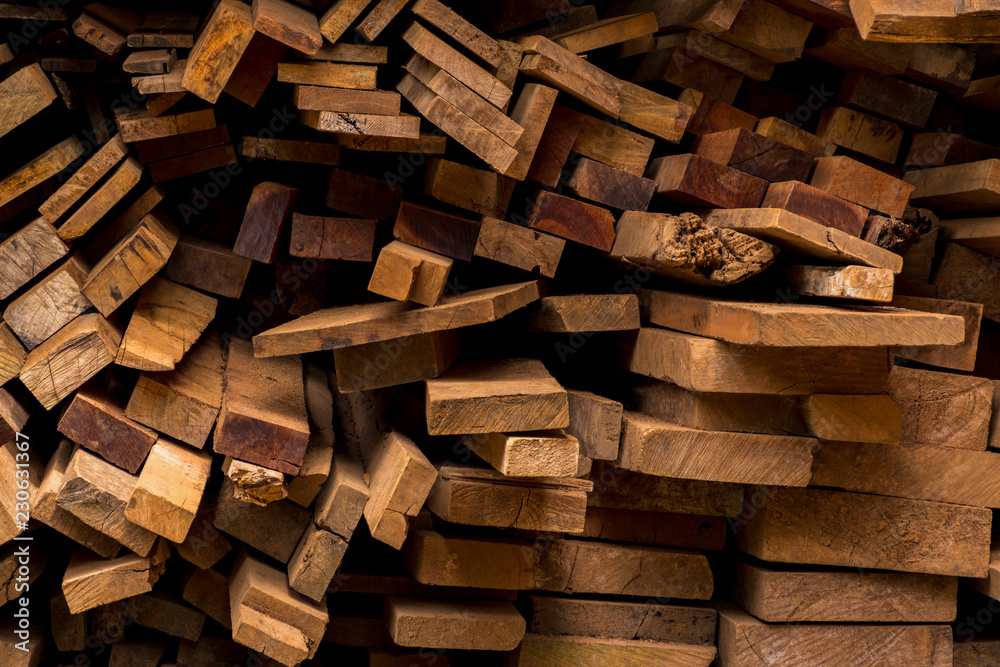 Industrial timber for construction. Old wood used to translate the picture. piled stack of natural brown uneven rough wooden boards lit. Industrial timber for construction. Old wood used to translate the picture. piled stack of natural brown uneven rough wooden boards lit.