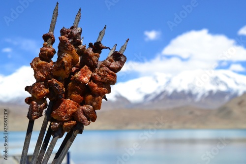 Chinese lamb meat skewers in Xinjiang Uyghur style barbeque, in mountains Karakul lake