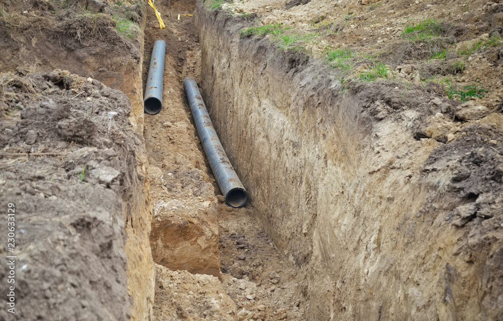 Trench excavated in ground for pipes and infrastructure construction. Trench excavated in ground for pipes and infrastructure construction.