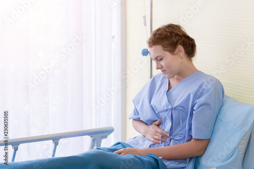 Beautiful young woman patient with period pain on hospital bed room.Copy space.