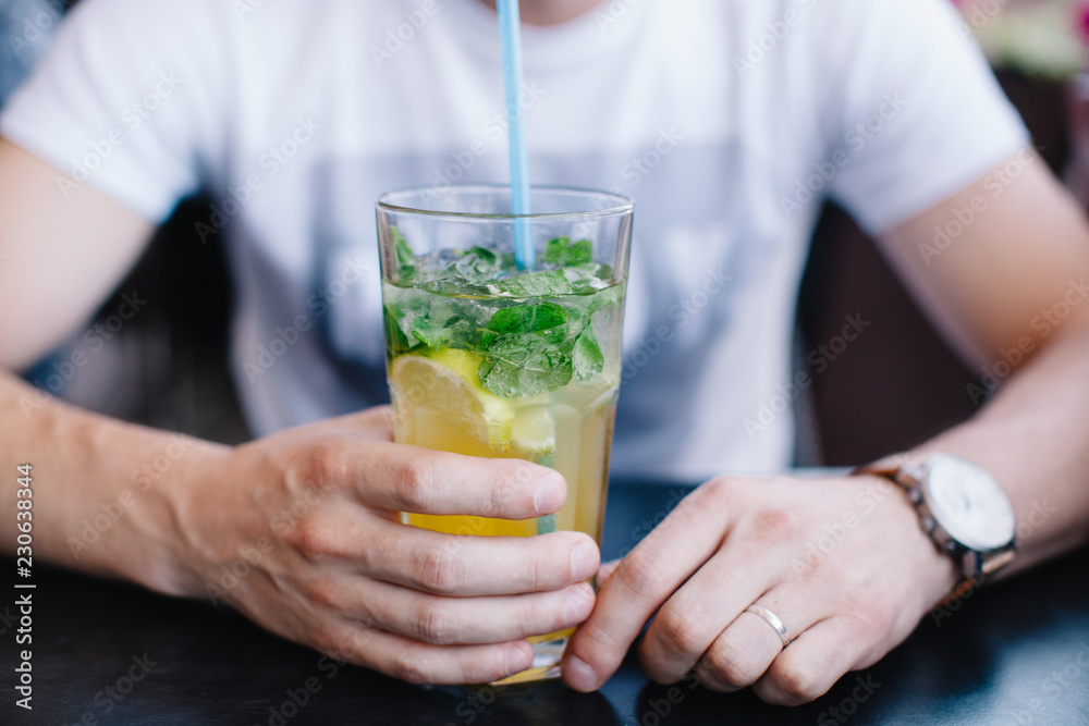 hands holding a glass of mojito hands holding a glass of mojito