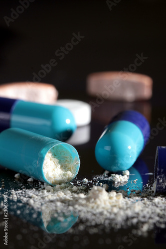 Opened blue pills with white powder close up