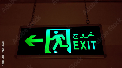 Fire Exit Sign Illuminating With Green Light - Urdu And English