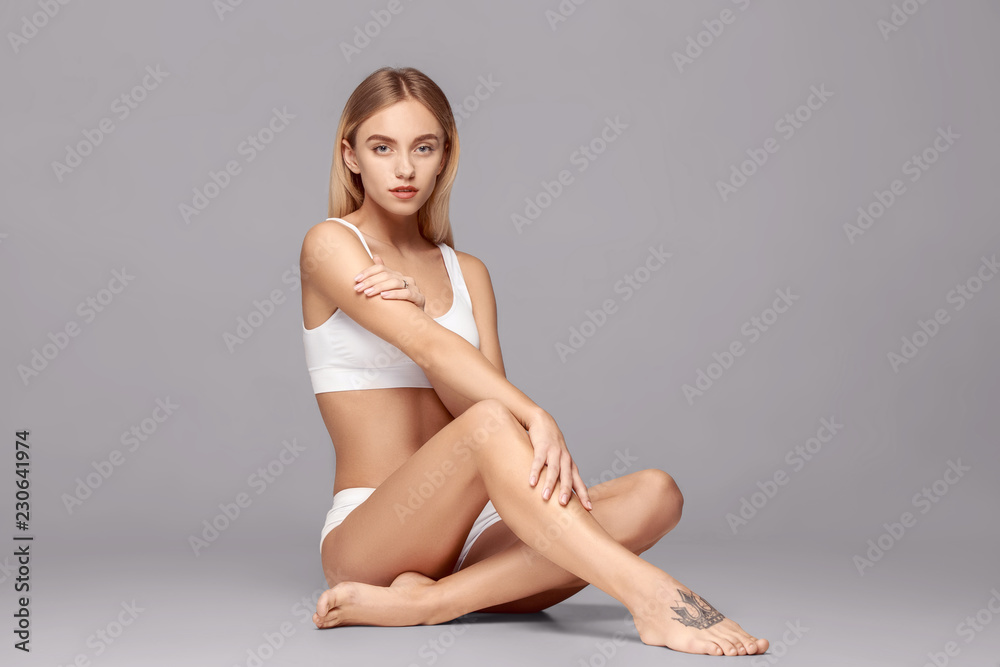 Perfect slim toned young body of the girl or fit woman at studio. The fitness, diet, sports, plastic surgery and aesthetic cosmetology concept.