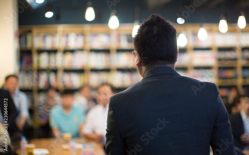 Speaker Giving Talk at Health Care Workshop Conference Meeting. Business Entrepreneurship Event. Person Giving Presentation During Corporate Seminar. Audience Attending Training Lecture Discussion.