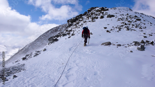 mountain climber on his way to a high alpine summit in the Alps of Switzerland