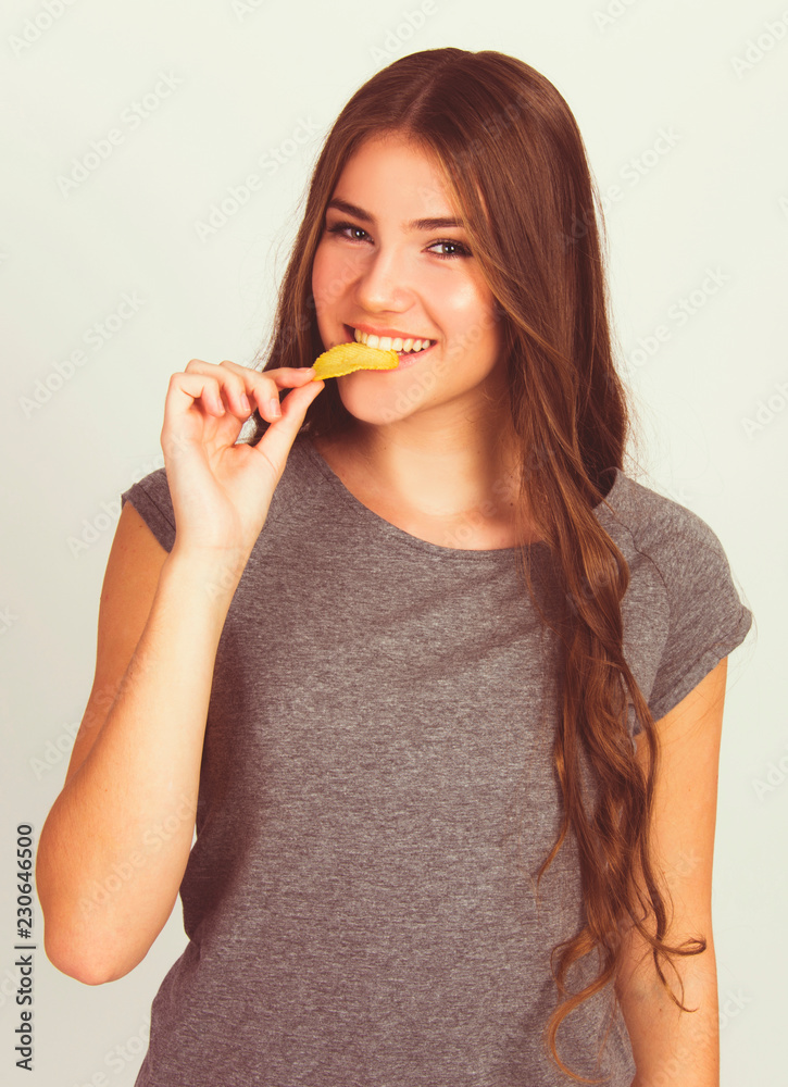 beautiful teen girl eating potato chips isolated on white model Caucasian beautiful teen girl eating potato chips isolated on white model Caucasian