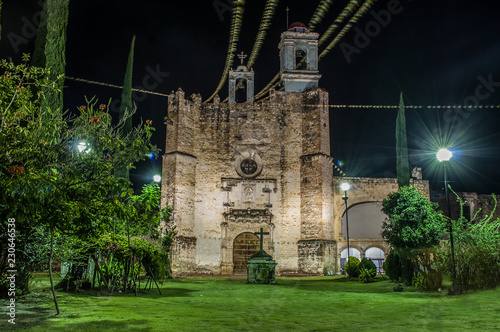 iglesia de huaquechula puebla mexico, vista nocturna y atardecer, entre nubes cruz en contraste photo