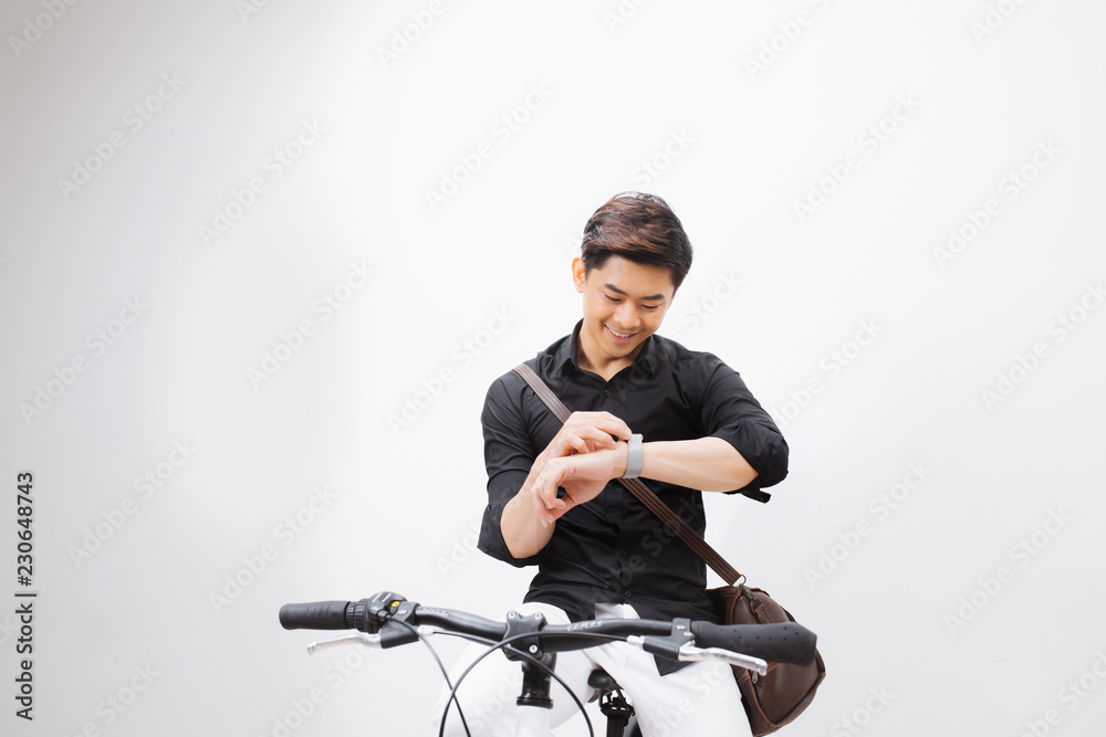 Handsome hipster enjoying a bike ride and checking time on his watch.