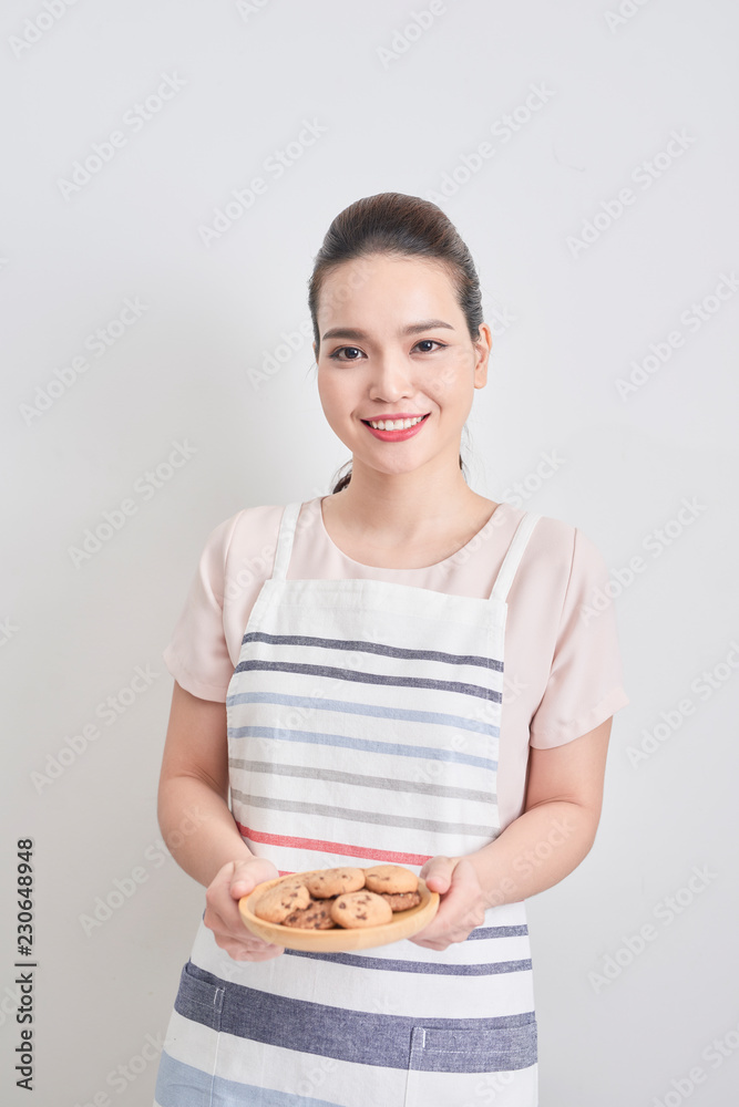 Young woman holding a plate of homemade chocolate cookies Young woman holding a plate of homemade chocolate cookies