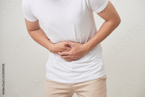 people, healthcare and health problem concept - unhappy man suffering from stomach ache over white background