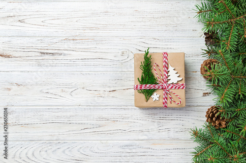 Christmas gift box wrapped in recycled paper, with ribbon bow, with ribbon on rustic background. Holiday concept photo