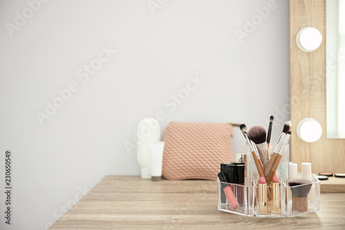 Fototapeta Makeup cosmetic products with tools in organizer on dressing table