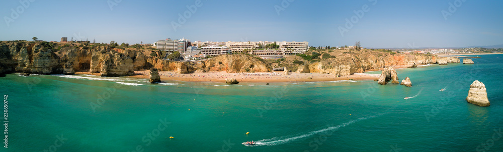 Aerial drone panorama photo - Scenic Praia Dona Ana of Lagos, Portugal. Rugged seaside cliffs and aqua ocean waters in the Algarve region of Portugal