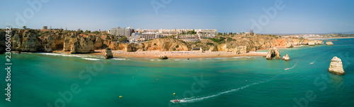Obraz na płótnie Aerial drone panorama photo - Scenic Praia Dona Ana of Lagos, Portugal. Rugged seaside cliffs and aqua ocean waters in the Algarve region of Portugal w salonie