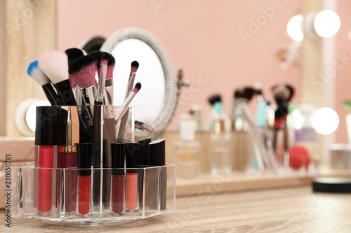 Organizer with cosmetic products for makeup on table near mirror. Space for text