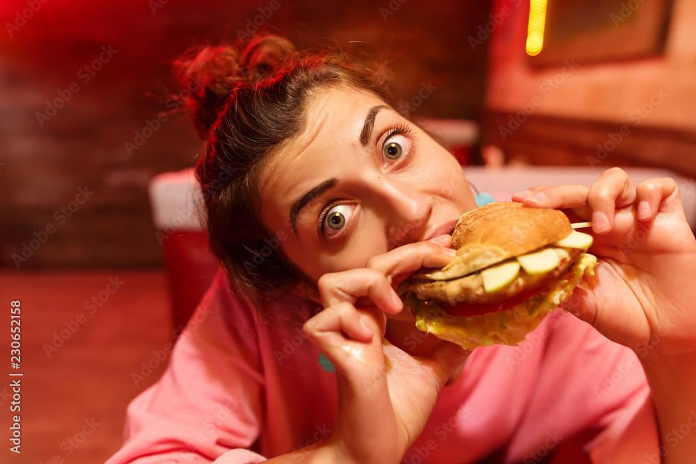 Girl with an appetite eats a big hamburger Girl with an appetite eats a big hamburger