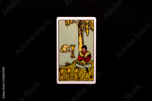 An individual minor arcana tarot card isolated on black background. Four of cups.
