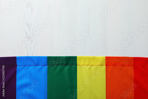 Rainbow gay flag on wooden background, top view with space for text. LGBT concept