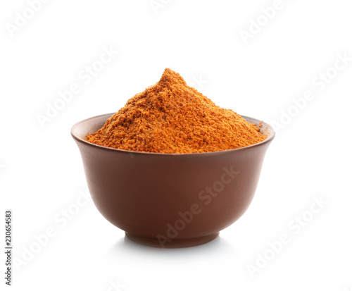 Bowl with red pepper powder on white background