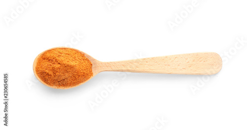 Wooden spoon with red pepper powder on white background, top view