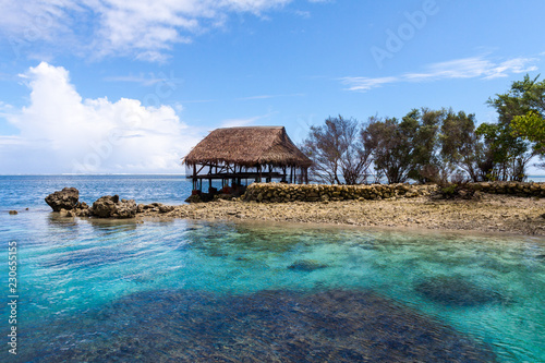 Traditional bungalow of native aborigines Micronesian people. Reef coral island motu. Blue azure turquoise lagoon with corals. Pohnpei island, Micronesia, Federated States of Micronesia (FSM), Oceania
