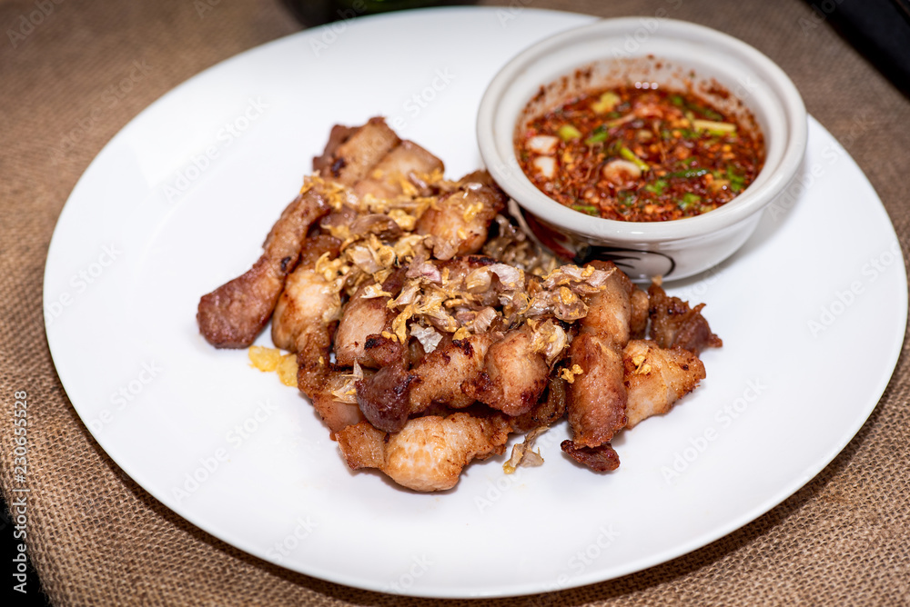 Fried sliced pork with garlic and pepper with purple rice Thai Recipes in White plate. Fried sliced pork with garlic and pepper with purple rice Thai Recipes in White plate.