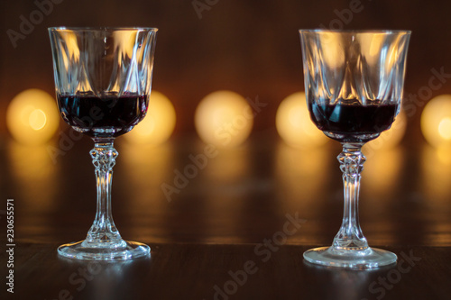 Two glasses of red wine with defocused lights on the background