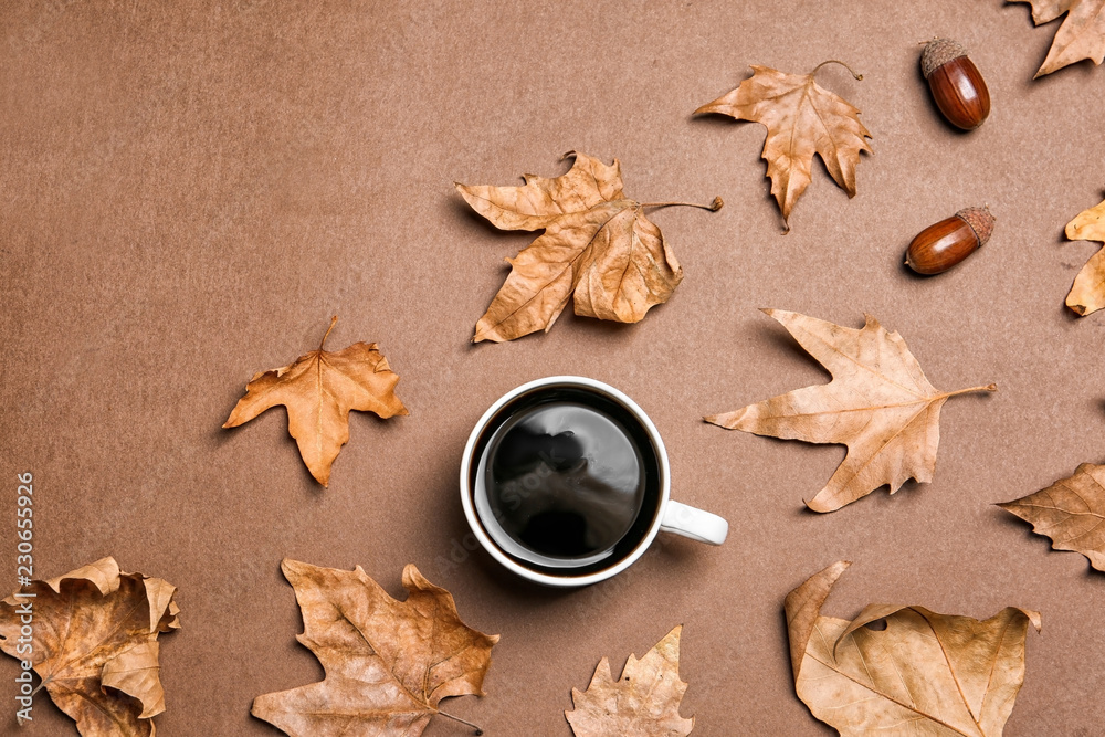 Flat lay composition with hot cozy drink and autumn leaves on color background. Space for text