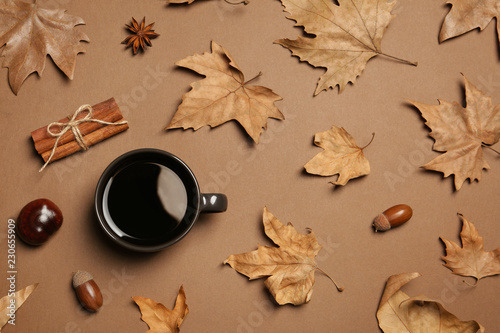 Flat lay composition with hot cozy drink and autumn leaves on color background