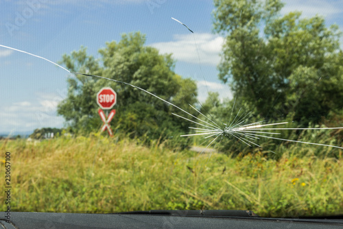 Kaputte Autoscheibe mit Stopp Tafel