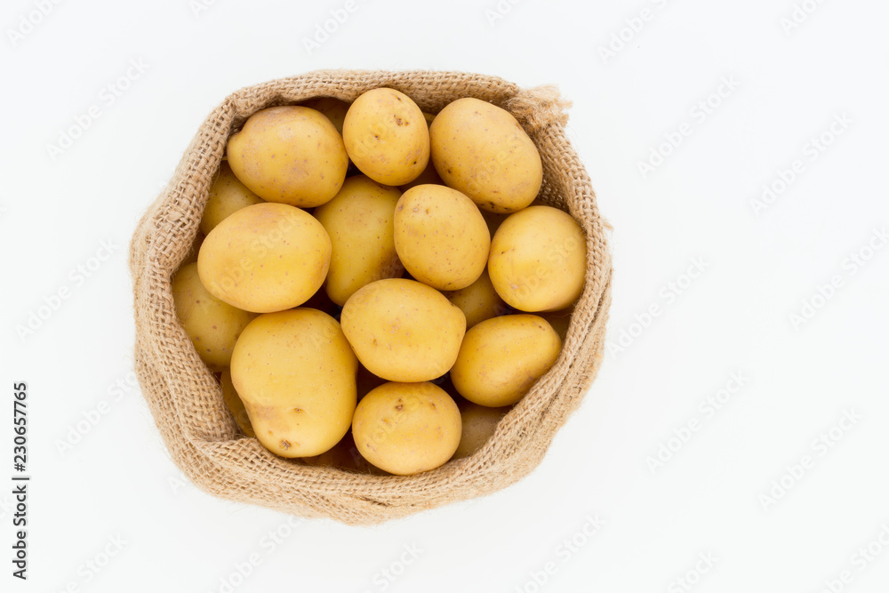 Sack of fresh raw potatoes on wooden background, top view Sack of fresh raw potatoes on wooden background, top view