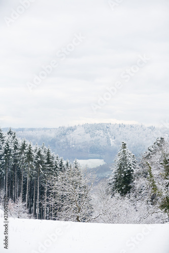 Beautiful winter landscape with snow covered trees and mountains and blue cloudy skies at frosty afternoon in Germany